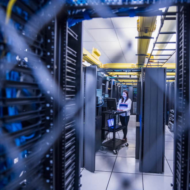 Technology expert checking infrastructure systems in a secure data center cage.