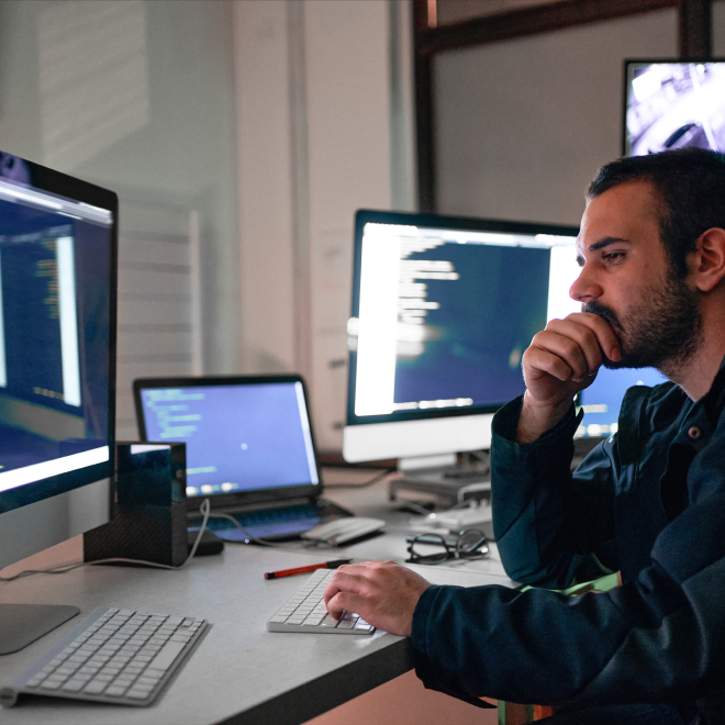 IT professional in an office monitoring infrastructure performance. 